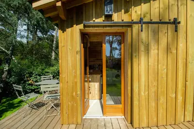 Jardin de l'établissement Cabane forêt proche plage avec piscine partagée