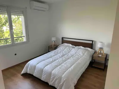 Un ou plusieurs lits dans un hébergement de l'établissement Maison 100m2 4 chambres avec piscine jardin paysage
