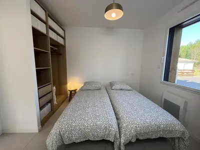 Un ou plusieurs lits dans un hébergement de l'établissement Maison en bois avec piscine proche de la plage