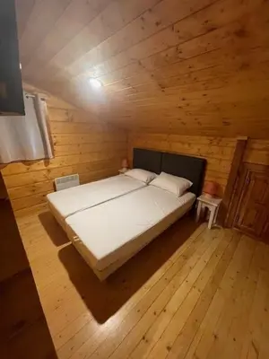 Un ou plusieurs lits dans un hébergement de l'établissement Chalet bois à Bias proche Mimizan