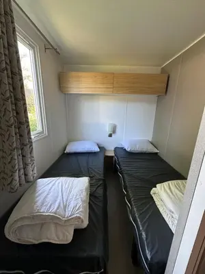 Un ou plusieurs lits dans un hébergement de l'établissement Location mobile-home confort face au lac
