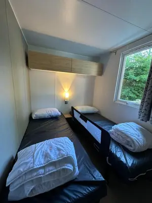 Un ou plusieurs lits dans un hébergement de l'établissement Location mobile-home confort face au lac