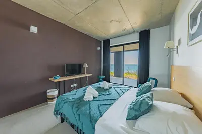 Un ou plusieurs lits dans un hébergement de l'établissement Villa Mer avec vue sur le bassin