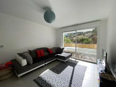 Coin salon dans l'établissement Appartement cosy proche centre Capbreton, situé dans un cadre boisé