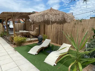 Jardin de l'établissement Maisonnette climatisée avec piscine et plage à 6mn