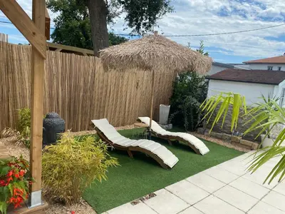 Jardin de l'établissement Maisonnette climatisée avec piscine et plage à 6mn