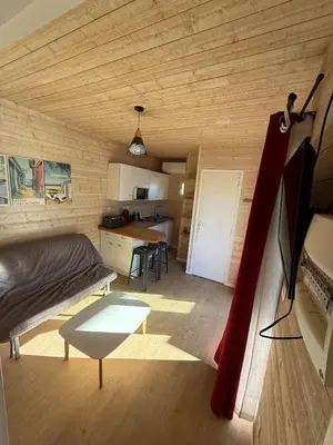 Coin salon dans l'établissement Chalet Boisé, climatisé - Piscine Village Khélus