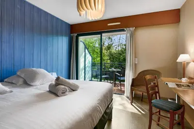 Un ou plusieurs lits dans un hébergement de l'établissement Hotel Le Pavillon Bleu