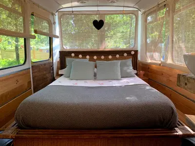 Un ou plusieurs lits dans un hébergement de l'établissement Magic Roof Top Bus with big bath in the tree forest!