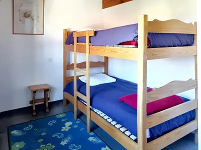 Un ou plusieurs lits dans un hébergement de l'établissement Maison accueillante à Vielle-Saint-Girons avec jardin et cheminée
